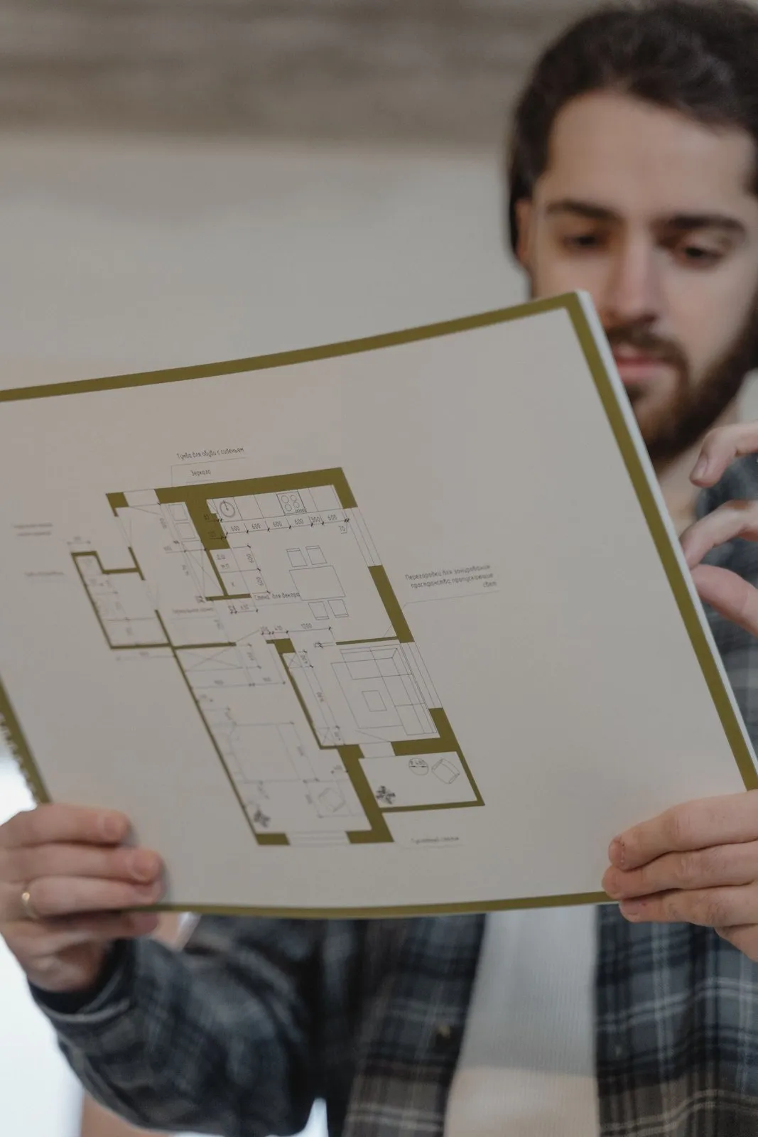 Persona revisando el plano de una vivienda de tres dormitorios antes de comprar