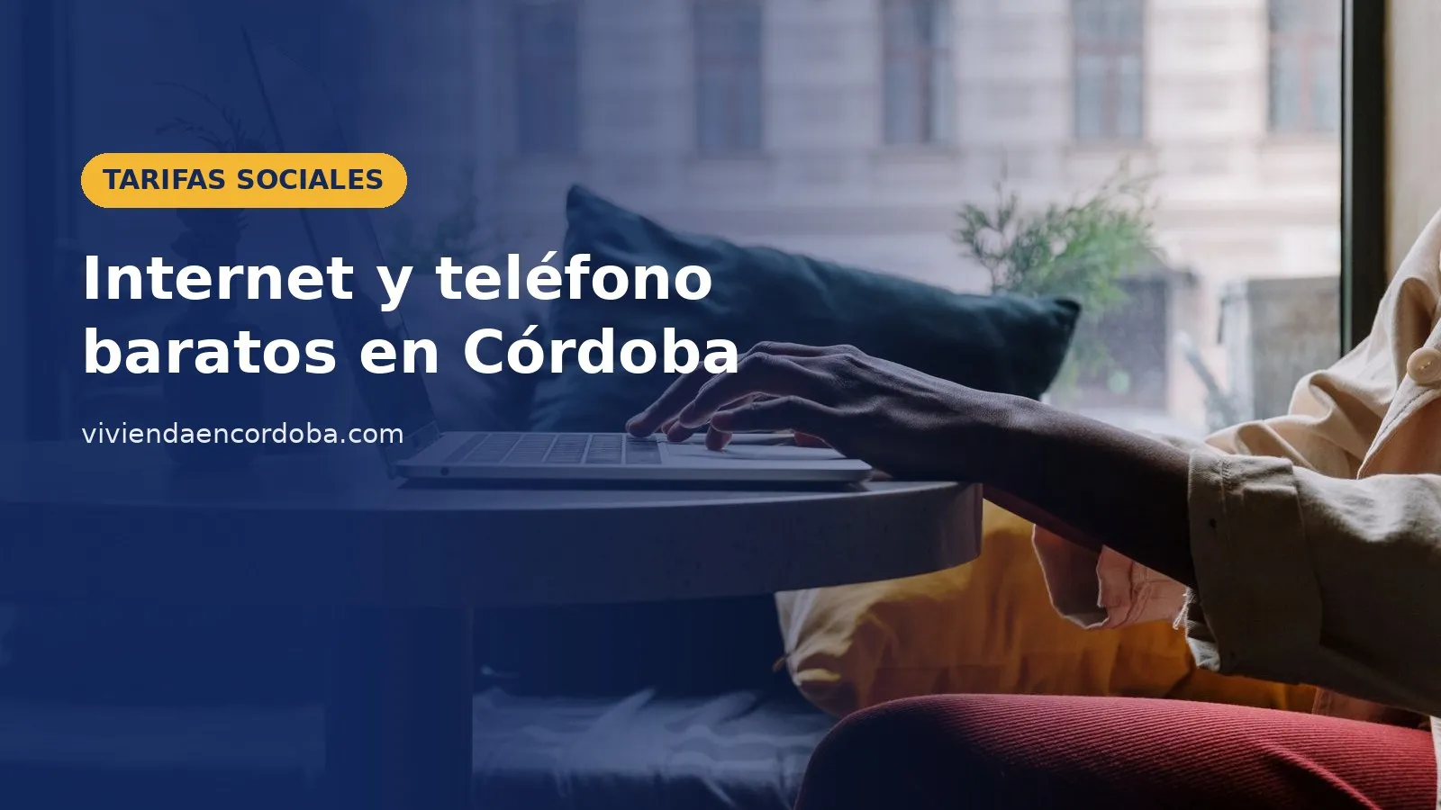 Persona trabajando con un portátil junto a la ventana, imagen sobre las tarifas sociales de internet y teléfono en Córdoba