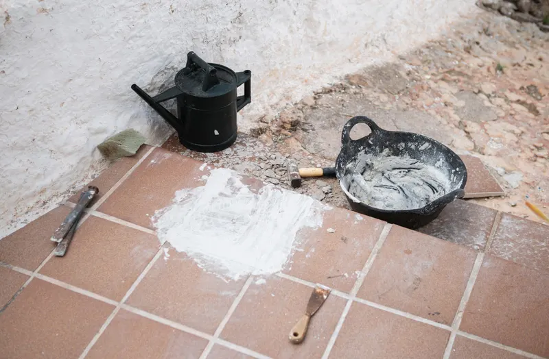Herramientas de albañil para reparar baldosas en una vivienda de Córdoba
