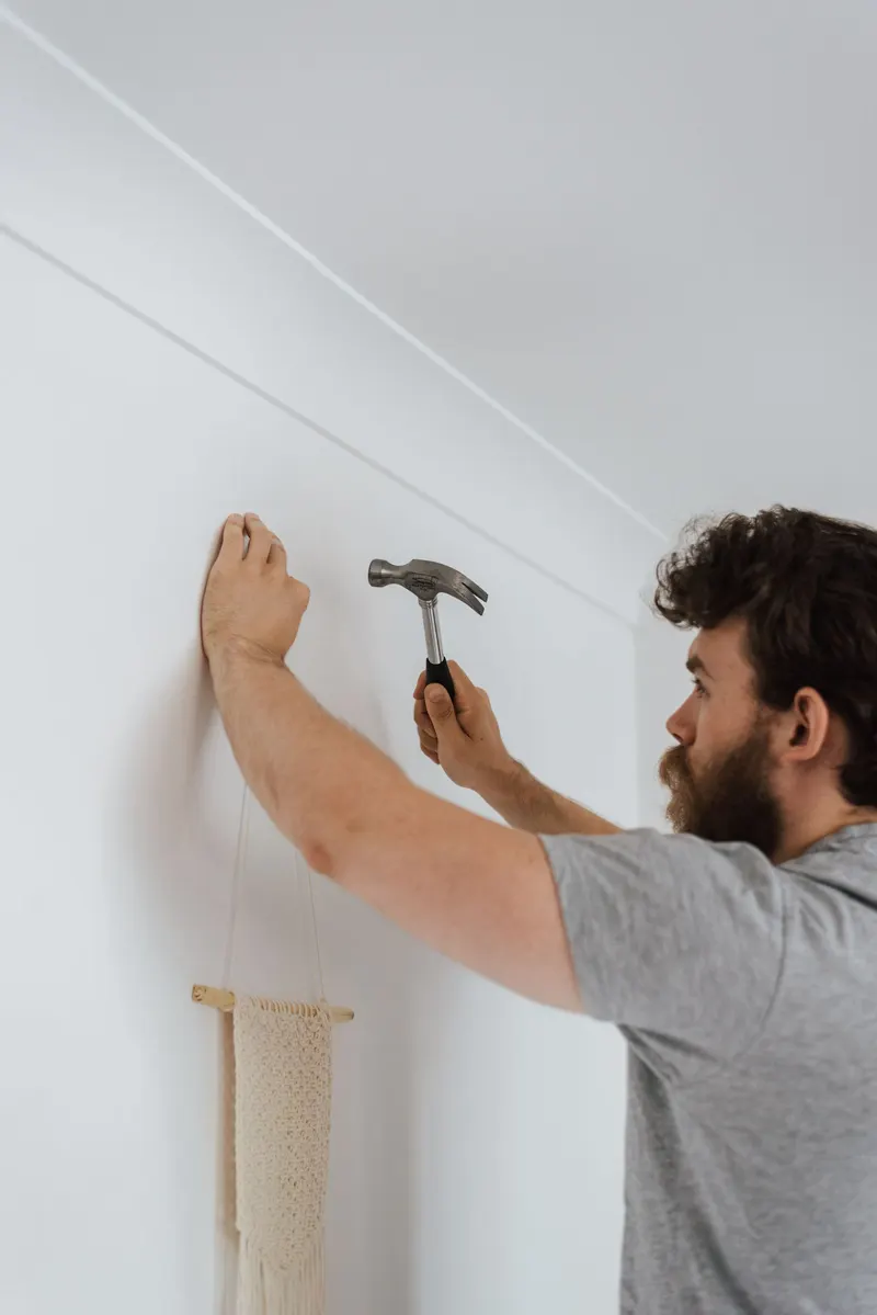 Manitas en Córdoba colgando un cuadro en la pared de una vivienda