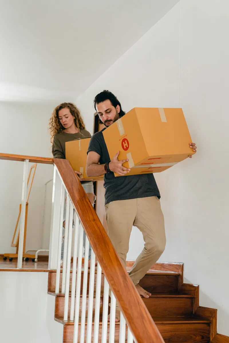 Mudanzas en Córdoba: pareja bajando cajas por la escalera