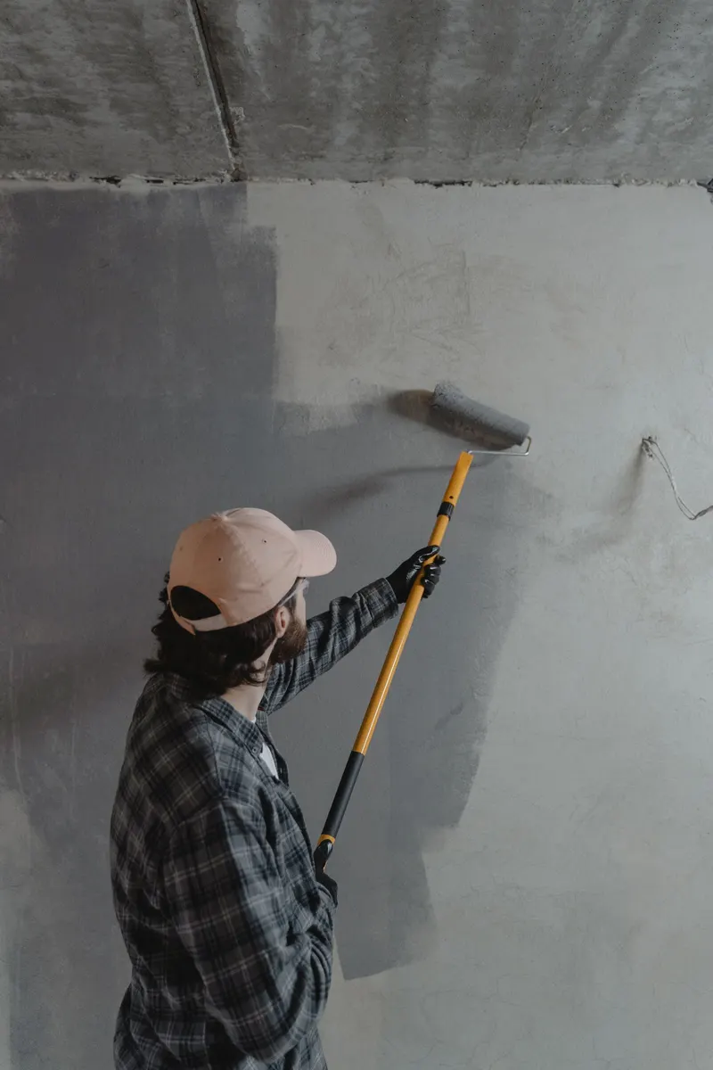 Pintor en Córdoba pintando una pared con rodillo