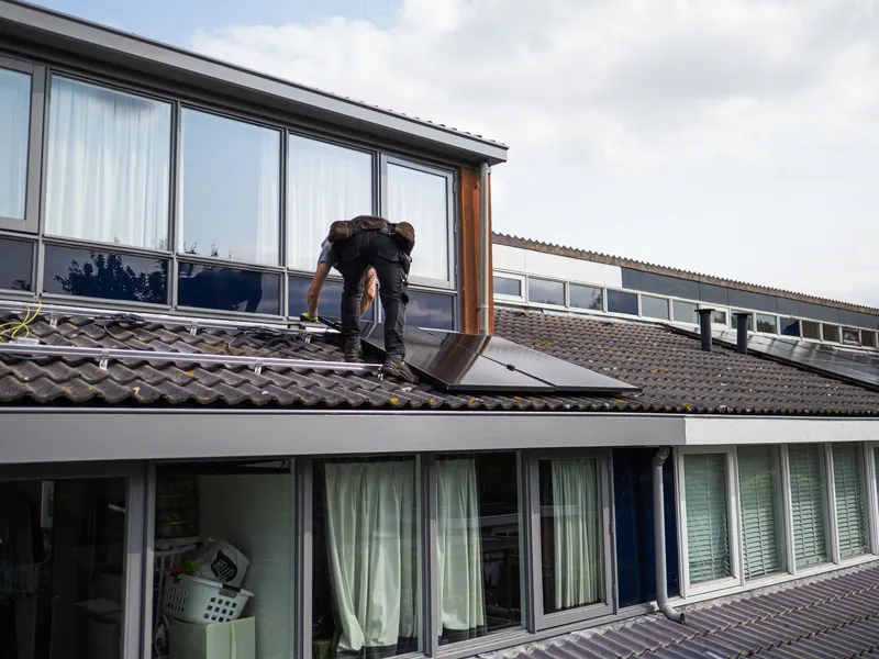 Técnico instalando paneles solares sobre un tejado