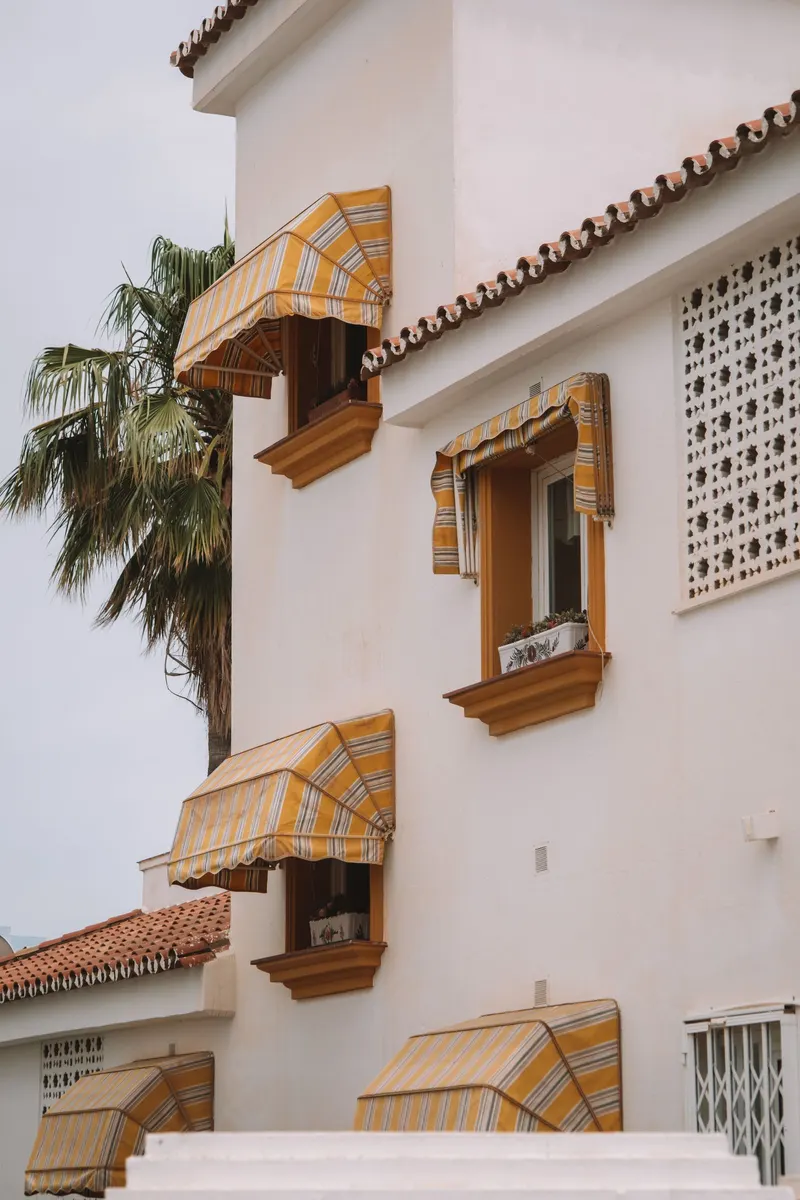 Toldos en Córdoba en las ventanas de una casa blanca andaluza